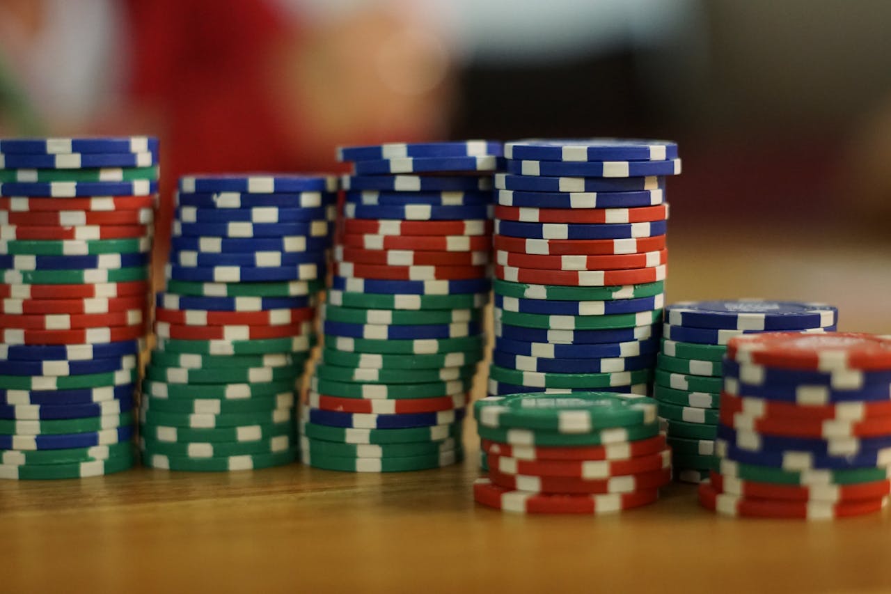 brand-03 A close-up view of colorful stacked poker chips on a wooden table, perfect for casino themes.