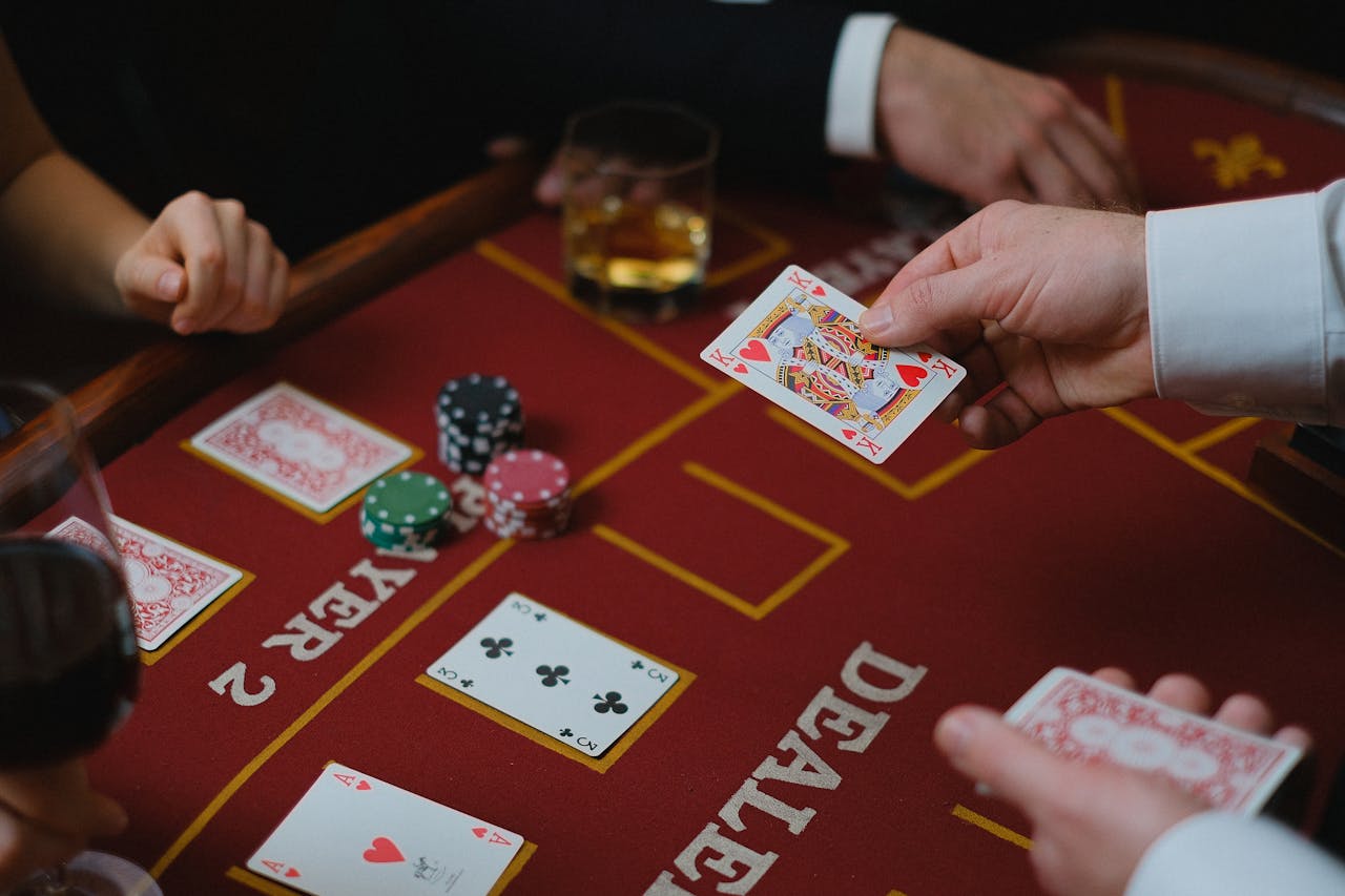 brand-02 Close-up view of a casino game with cards and chips on the table, featuring player interaction.